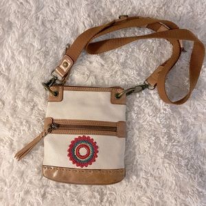 The Sak cream leather crossbody purse with festival embroidered sun on front